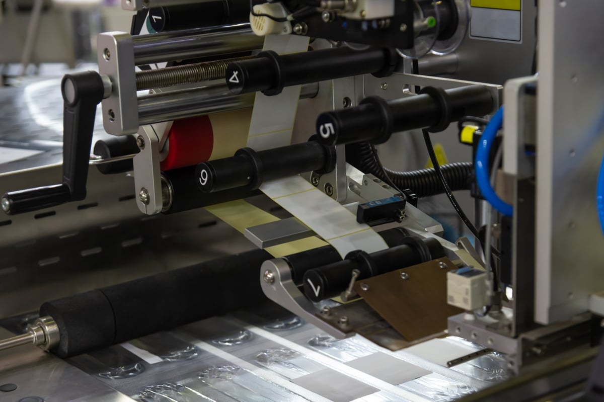 Máquina de impresión aplicando etiquetas en un rollo dentro de una planta