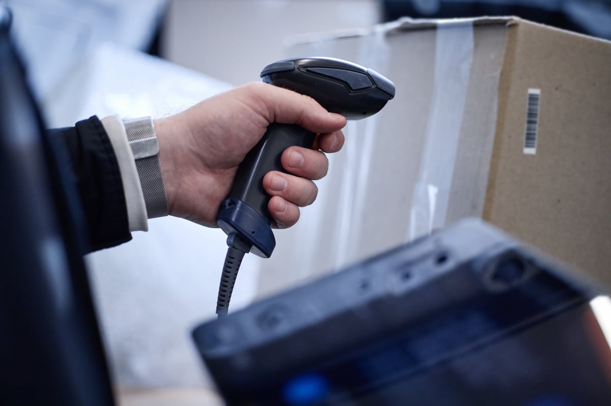 Trabajador escaneando el código de barras de una caja en almacén
